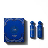 The image shows the "Legend of the Sky" perfume set by Gissah, which includes two blue bottles labeled "Nexus" and "Horizon." The bottles are set against a blue box with elegant gold and white detailing and the collection name "Legend of the Sky" prominently featured in the center. The design of the box mirrors the ornate style of the bottles' caps, creating a cohesive and visually appealing presentation that suggests a luxurious fragrance experience.