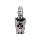 The image features an ornate perfume bottle. The bottle has a dark body with a silver filigree design encrusted with crystals, highlighting a prominent purple flower-shaped jewel at the center. It's topped with a faceted crystal cap that adds to the luxurious appeal. The intricate details suggest a bespoke and opulent scent contained within. The overall design of the bottle conveys a sense of vintage elegance and exclusivity.