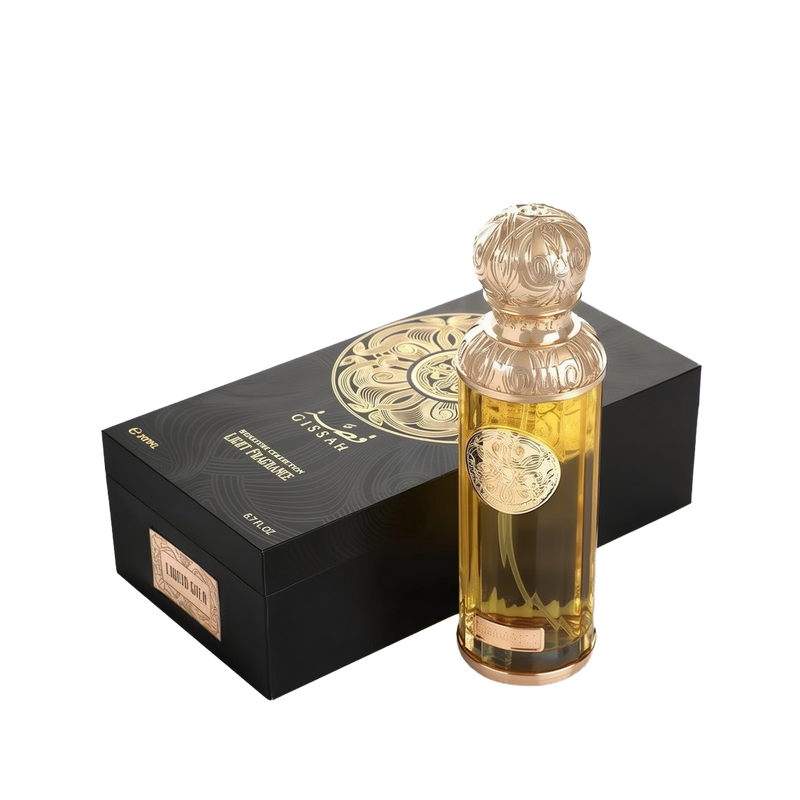 A product image of Gissah’s “Liquid Gold” signature light fragrance: a sleek rectangular black gift box embellished with an intricate gold filigree medallion design and branded in white and gold with “Gissah” (in Arabic and English), “Signature Collection Light Fragrance,” and “200?ml / 6.7?fl oz.”