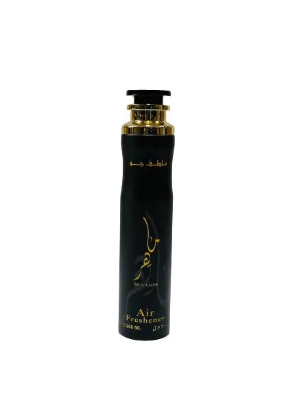 The image displays a sleek, black air freshener bottle with a golden neck and cap. The bottle has golden Arabic calligraphy along with English text "Maahir" and "Air Freshener 300 ML" in a golden script. The design is simple yet elegant, with the gold text providing a contrast against the dark bottle. The background is neutral, allowing the product to stand out.