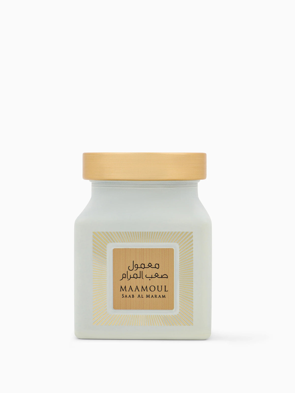 The image shows a jar labeled "Maamoul Saab Al Maram". It's a matte grey jar with a natural wooden lid. On the front, there's a beige label with sunburst lines in a pale yellow color. The product's name "Maamoul" is at the top of the label in bold English letters, with "Saab Al Maram" beneath it in a smaller font, along with Arabic script.