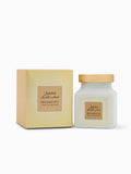 The image features a product set of Maamoul Saab Al Maram, which includes a square box and a jar. The box and jar both have a pale yellow background with a white and gold sunburst pattern. The label on both is beige with a border that matches the sunburst pattern, and it displays the product name "Maamoul" in bold English lettering above the scent name "Saab Al Maram," with corresponding Arabic script. The jar has a matte grey body and a natural wooden lid.