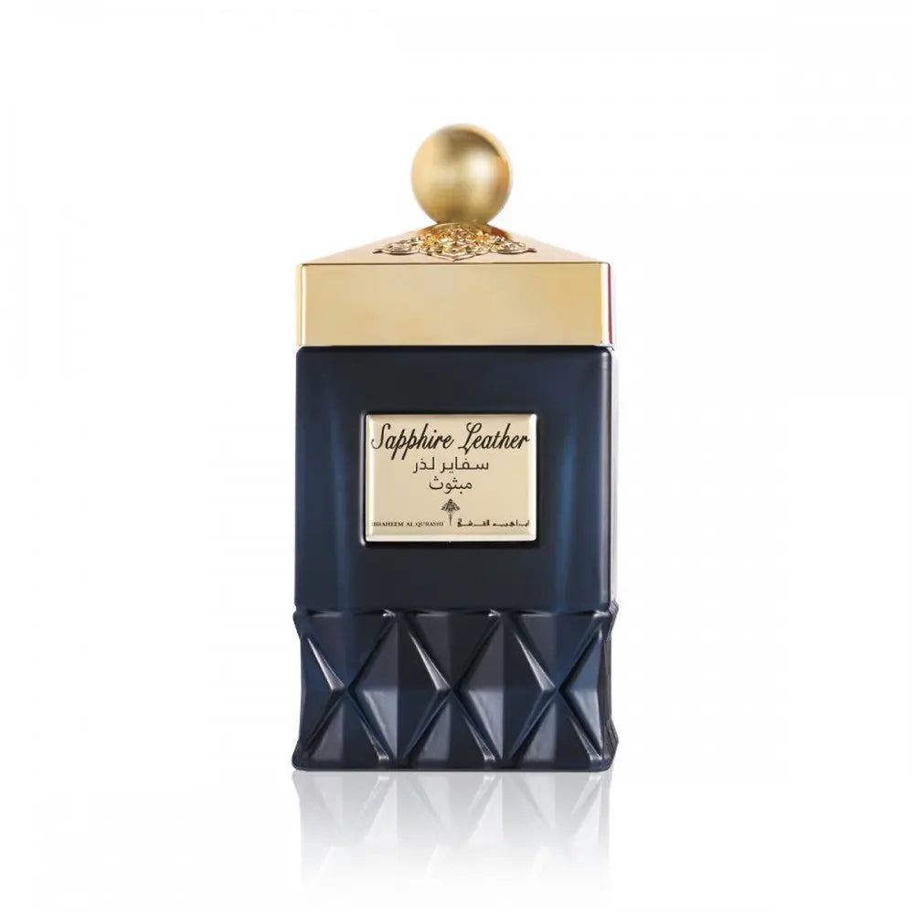 The image presents a dark navy blue perfume bottle and its packaging on a white background. The bottle has a lower half with a faceted design reminiscent of a gemstone, and a smooth upper half with a gold label that features the name "Sapphire Leather" in English and Arabic script. It is topped with a golden cap with decorative texturing and a spherical knob.