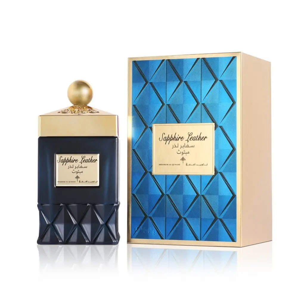 The image shows a product which appears to be a perfume named "Sapphire Leather" by Ibraheem Al Qurashi. It includes a dark blue glass bottle with a textured design on the lower half and a gold-colored neck and cap. There is a label on the bottle with the name of the perfume in both English and Arabic script. Beside the bottle is a box with a blue textured pattern and a gold label that matches the bottle's label. The box has a beige side panel, suggesting a three-dimensional perspective. 