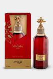 The image shows a bottle of "Magma Love" eau de parfum by Zimaya alongside its packaging. The perfume bottle is deep red with a faceted design and a gold label that reads "MAGMA LOVE" and "zimaya" at the bottom. The cap is an ornate gold structure with a decorative, flower-like design on top, adding a luxurious touch. The packaging box matches the bottle's design, with a red and gold color scheme and a geometric pattern.