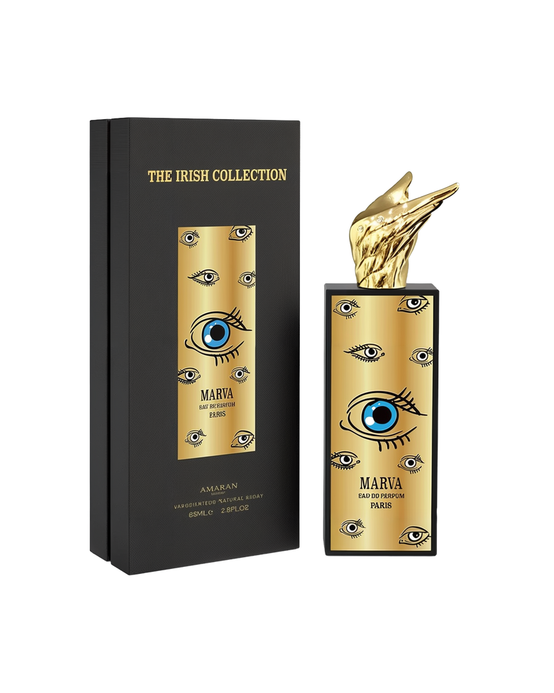 A tall rectangular black perfume bottle with a gold front panel decorated with stylized eye graphics, labeled “Marva” by Amaran. The bottle is topped with a sculpted gold wing cap and displayed next to a black box reading “The Irish Collection,” indicating 85ml (2.8 fl oz) Eau De Parfum.