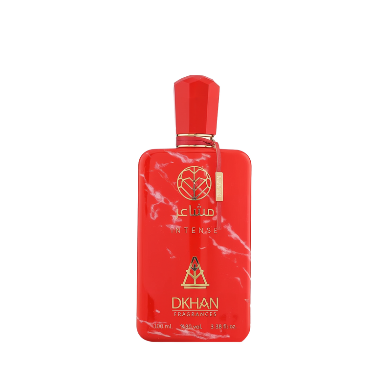 This is an image of a bold red perfume bottle with white marble-like patterns. The bottle has a geometrically shaped cap and a gold-colored label attached to the front. The label features the word "club" in lowercase letters followed by "INTENSE" in uppercase. Below, there is a logo comprising a heart inside a diamond shape and the text "DKHAN FRAGRANCES." 