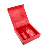 This image displays a luxurious fragrance gift set by DKHAN Fragrances. The set is presented in an elegant red box with the lid partially open, revealing the interior. Inside the box, nestled in a plush red lining, are two items: a larger red perfume bottle with a white marbled design and a smaller red bottle, both emblazoned with the DKHAN logo. The inside of the lid features a sophisticated design with wavy lines and the DKHAN Fragrances logo prominently at the center.