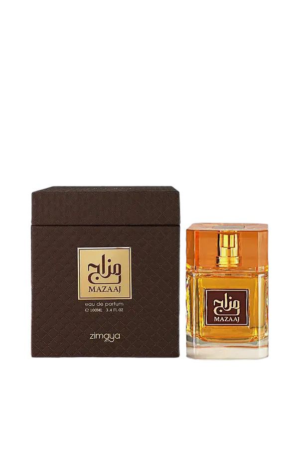 The image shows a bottle of "Mazaaj" eau de parfum by Zimaya alongside its packaging. The perfume bottle is rectangular and made of clear glass, showcasing the golden-yellow liquid inside. It has a matching golden-yellow cap with a faceted design. The front of the bottle features a brown label with gold text in Arabic and English, reading "Mazaaj." The packaging box is dark brown with a textured pattern and has a matching gold and brown label.