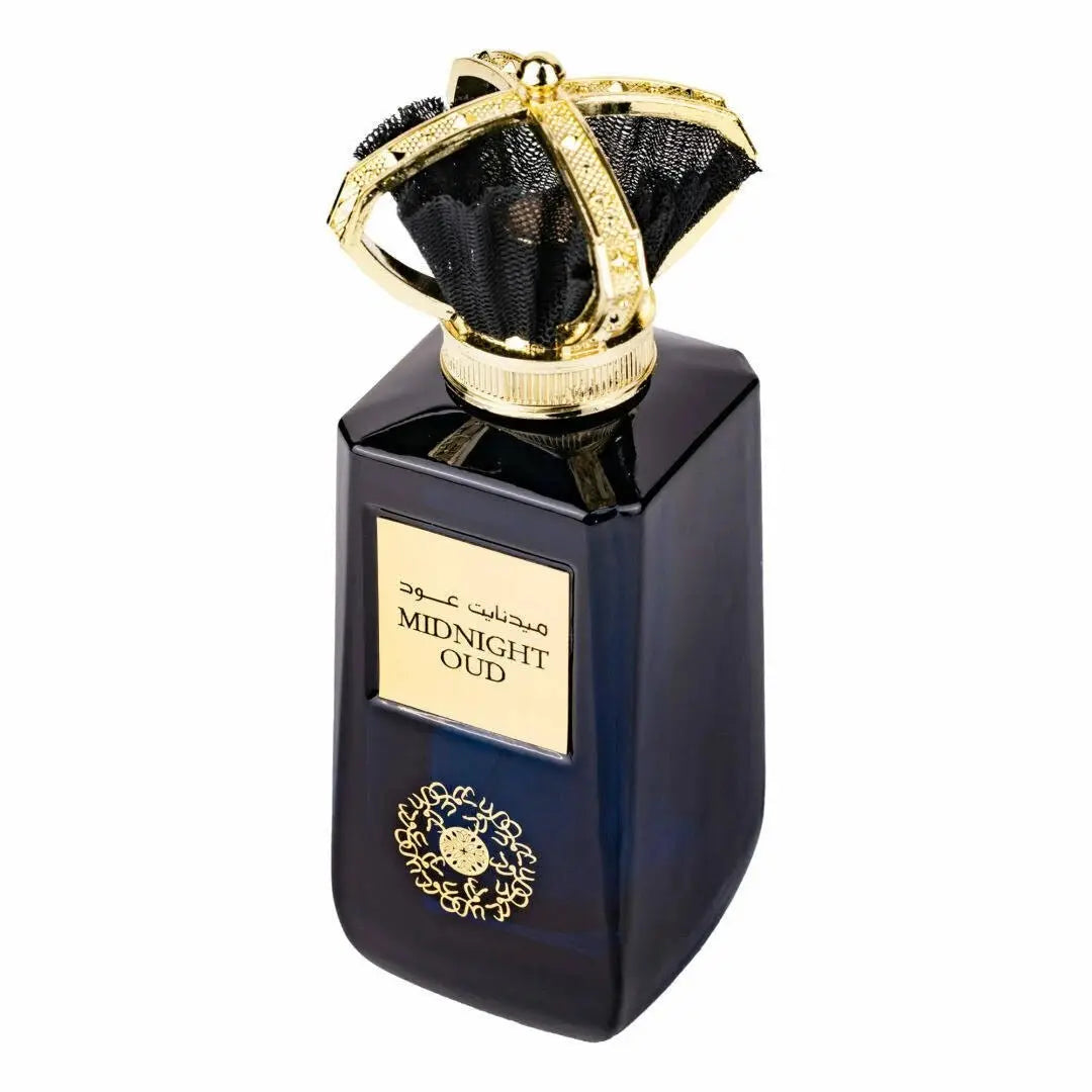 The image features a sophisticated dark blue, almost black, perfume bottle with a luxurious golden cap. The cap has a distinctive design that resembles a royal crown, adorned with a black net-like material stretched within its frame, adding to the opulent look. On the front of the bottle, there is a gold-framed label with the name "MIDNIGHT OUD" in bold letters, and below it, Arabic calligraphy that likely mirrors the name of the perfume. 