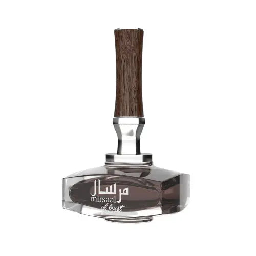 An image of the Mirsaal of Trust EDP 90ml perfume bottle, showcasing a clear glass design with a dark fragrance liquid. The bottle features a unique cap with a wood grain texture, above a silver neck that provides a striking contrast. The front of the bottle is adorned with the perfume's name 'mirsaal of trust' in both Arabic and English script, set against a simple yet elegant backdrop, emphasizing the fragrance's refined and trustworthy essence.