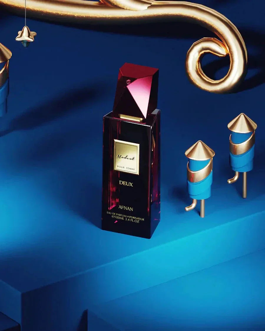 The image presents the Modest Deux Pour Femme perfume by Afnan Perfumes in an artistic setting. The bottle is placed against a backdrop of deep blue hues with golden and blue decorative elements, creating a luxurious and mysterious atmosphere. The perfume bottle, with its burgundy color and geometric, reflective cap, stands out as a centerpiece, exuding elegance and a contemporary aesthetic. 