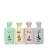 This image features a collection of four musk-inspired perfume bottles from DKHAN Fragrances, lined up against a plain background. Each bottle has a distinct pastel color and geometric cap design, corresponding to the fragrance it holds. From left to right: the first bottle is a soft mint green labeled "MUSK LOLO," the second is a gentle yellow with "MUSK MANGO," the third is a pale pink for "MUSK POWDER," and the fourth is a light grey labeled "MUSK CHOCO."