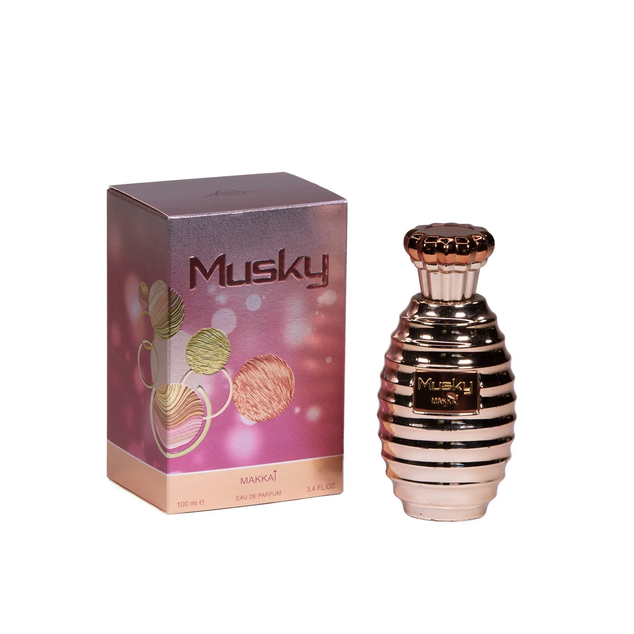 The image shows a product called "Musky Makkaj," which is a perfume. Displayed are both the perfume bottle and its packaging box. The bottle is metallic pink with horizontal stripes and a decorative gold and black cap. The box is purple with a gradient effect, decorated with stylized illustrations of plants in gold, pink, and green, and features the name "Musky" prominently with a smaller "Makkaj" below it.