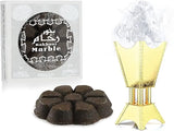 The image displays "Bakhoor Marble" by Nabeel Perfumes. On the left is a white box with a transparent window revealing dark, pyramid-shaped bakhoor pieces. The box features a black circular label with intricate white patterns, Arabic script, and the product name in English. To the right is an artistic rendering of a gold bakhoor burner with smoke wafting from it, signifying the product's use.