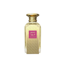 The image shows a rectangular glass perfume bottle with a gold-colored cap. The body of the bottle is adorned with a dense pattern of embossed or etched geometric lines, giving it a textured appearance. A prominent label with Arabic script is placed in the center of the bottle, featuring a magenta background which stands out against the golden tones of the bottle's design. The label text "Naseej Al Ward" is also visible in Latin script, suggesting the name of the perfume or the brand. 