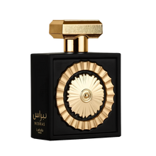 The image features a sophisticated perfume bottle with a black rectangular body and a distinctive golden circular motif in the center, resembling a sun or wheel design. The bottle has a textured gold cap with geometric shapes. Arabic script on the bottom 