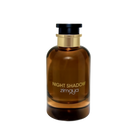 The image shows a cylindrical amber glass perfume bottle with a black cap and a gold band around the neck. The bottle has the text "NIGHT SHADOW" printed in large, capitalized, serif font in the center, with the brand name "zimaya" in a smaller, simple font below. The background is plain and white, highlighting the product.