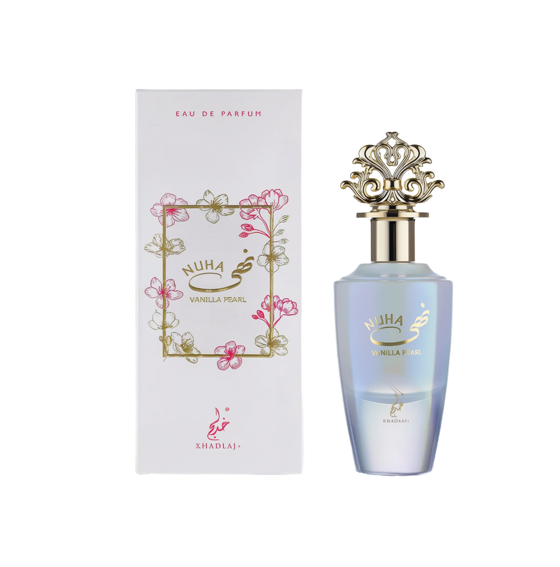 A pearlescent gradient perfume bottle labeled ‘Nuha Vanilla Pearl’ with an ornate gold crown cap, displayed alongside a white box featuring delicate pink floral illustrations and gold lettering from Khadlaj.
