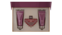 The image shows a gift set by Afnan Perfumes, "ORNAMENT purple allure". It features a perfume bottle and two tubes of shower gel, all in a coordinated deep purple color. The bottle has a unique, cross-shaped design with a red body and silver metalwork. The shower gels are labeled "ENERGIZING SHOWER GEL POUR FEMME" and are housed in sleek, metallic purple tubes.