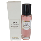 The image features a perfume set from the Privée Couture Collection named "OUD ISPAHAN." On the left is the outer packaging, a tall, slender rectangular box in a soft off-white color with a framed label matching the bottle's label. On the right side stands the perfume bottle, a clear cylindrical container with a rosy pink fragrance liquid. It has a black cap, and the label on the bottle is bordered and reads "OUD ISPAHAN PRIVÉE COUTURE COLLECTION" in black lettering on a cream background.