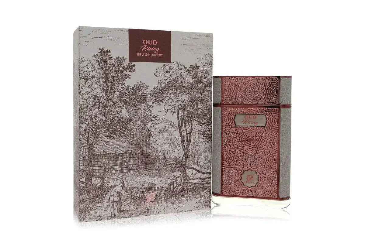 The image shows a perfume bottle next to its packaging. The perfume bottle is rectangular with a flat profile, designed in dark maroon with embossed geometric patterns and a silver-grey textured band.  Adjacent to the bottle is the box packaging, which displays a detailed, vintage-style drawing of a pastoral scene with trees, a cottage, and a figure near a fence, rendered in monochrome. The bottle and packaging are set against a neutral background, highlighting the elegance of the product. 