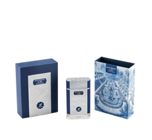 The image showcases a set of perfume products with their packaging. There are two boxes and one perfume bottle, all with a consistent color theme of navy blue and white. The box on the left is navy blue with a textured pattern and a white label that reads "PATCHOULI eau de parfum" along with the "AFNAN" logo.  To the right is another box with a detailed blue and white illustration of a classical garden scene, including a fountain and neatly trimmed hedges.
