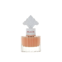 The image features a clear glass perfume bottle filled with a peach-colored liquid. The bottle has a white cap with the word "PEACH" in a peach font color. Atop the cap is an ornate white design, detailed and intricate, possibly inspired by Middle Eastern art.