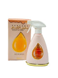The image features a room and linen mist spray bottle alongside its packaging box. The bottle is a soft peach color with a white spray nozzle and a gold base. It has a teardrop-shaped transparent window with Arabic script and the name "ZEENAT AL FARSH" in both Arabic and English, set within an orange-colored backdrop.  The packaging box echoes the bottle's color scheme with a peach background and a teardrop motif. It has the text "PERFUME AQUA ZEENAT AL FARSH" along with "ROOM AND LINEN MIST" printed on it.