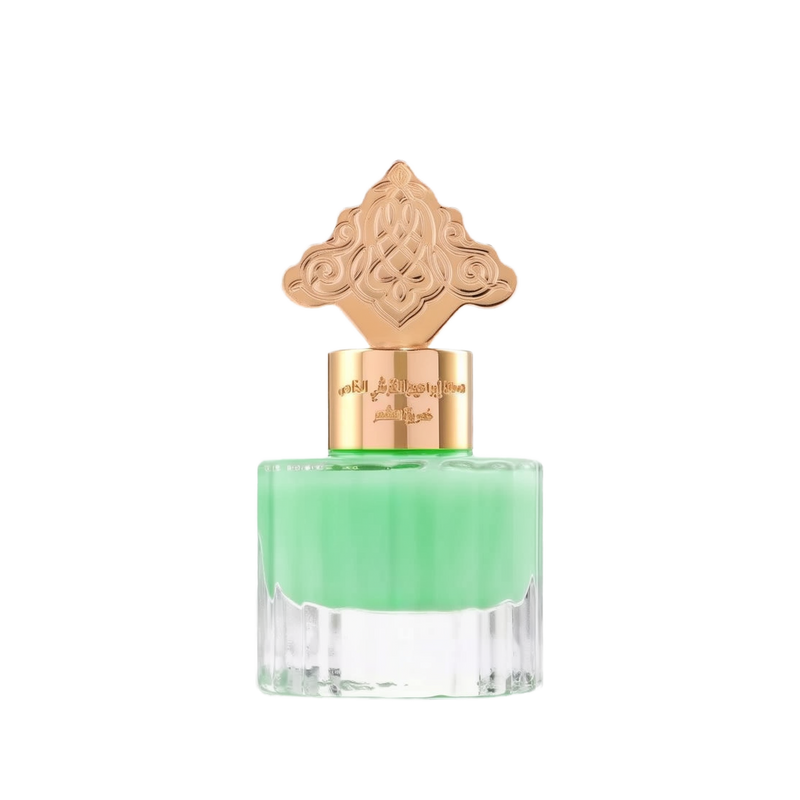 This is an image of a perfume bottle with a clear base and a vibrant green liquid inside. The cap is ornate and gold-colored, featuring an intricate design that suggests an inspiration from Middle Eastern or Islamic art. There is Arabic calligraphy on the gold band around the neck of the bottle, likely indicating the fragrance's name or brand.