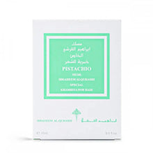 The image displays a fragrance product's packaging box. The box is white with a bright green label framed within a larger white border. The label contains text in both English and Arabic, indicating the fragrance name "PISTACHIO MUSK," the brand "IBRAHEEM AL QURASHI SPECIAL," and the product type "KHAMRIYA FOR HAIR." The box also notes the quantity as "15ml / 0.5 fl.oz."