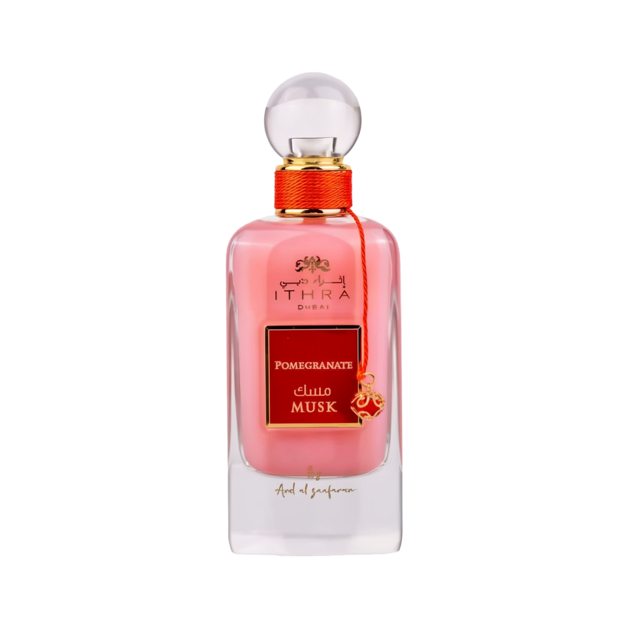 A bottle of Ithra Dubai Pomegranate Musk perfume by Ard Al Zaafaran. It features a clear glass design with a white gradient base and a round glass cap. The perfume liquid has a soft pink hue, and there's a gold-colored brand emblem at the top, with the name of the scent on a red and gold label in the center. A small gold charm with intricate detailing is attached to the neck of the bottle with a red string. The presentation suggests a feminine and luxurious fragrance.
