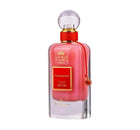A perfume bottle labeled "Pomegranate Musk" from the Ithra Dubai collection by Ard Al Zaafaran. The perfume liquid is a translucent pink, and the bottle has a gold-threaded neck with a clear, spherical cap. A small, ornamental gold charm with a pomegranate design is attached to the neck by a red cord. The label is framed in gold with a red background, and the text is in both Arabic and English. The overall design suggests a luxurious and fruity fragrance.