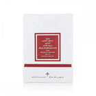 The image displays a white square box with a deep red label framed in gold, indicating a luxury hair product named "ABAQ POMEGRANATE MUSK" by Ibraheem Al Qurashi. This product appears to be part of a special "KHAMRIYA" collection for hair care. The text on the box is likely in both Arabic and English, denoting an exclusive or premium range. 