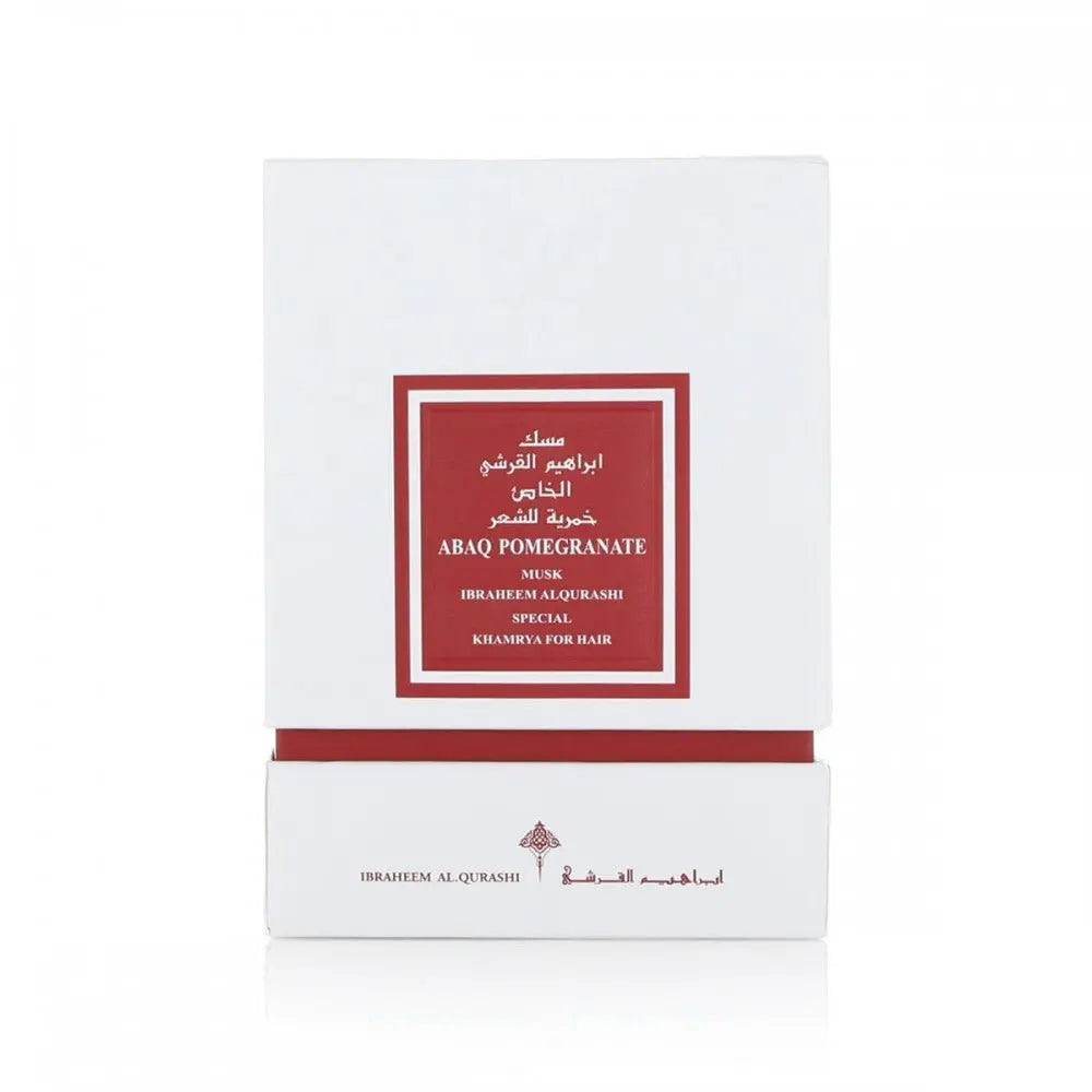  The image displays a white square box with a deep red label framed in gold, indicating a luxury hair product named "ABAQ POMEGRANATE MUSK" by Ibraheem Al Qurashi. This product appears to be part of a special "KHAMRIYA" collection for hair care. The text on the box is likely in both Arabic and English, denoting an exclusive or premium range. 