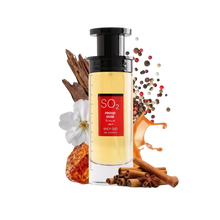 An image of a tall, rectangular perfume bottle with a yellow to amber gradient liquid and a black cap. The label has a prominent red rectangle with the text "SO2 PROUD DOSE SPICY OUD" in both English and Arabic. The product is presented with visual elements that suggest its fragrance notes: white flowers, cinnamon sticks, star anise, amber resin, and a sprinkle of multicolored peppercorns.
