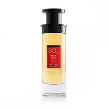 The photograph displays a tall, elegant perfume bottle with a gradient of yellow to amber liquid and a black cap. A red label on the bottle features the name "SO2 PROUD DOSE SPICY OUD" in bold white letters with Arabic script beneath it. The bottle's simple design against a white background highlights the product's sleek appearance and the warm color of the perfume, suggesting a luxurious and exotic scent.