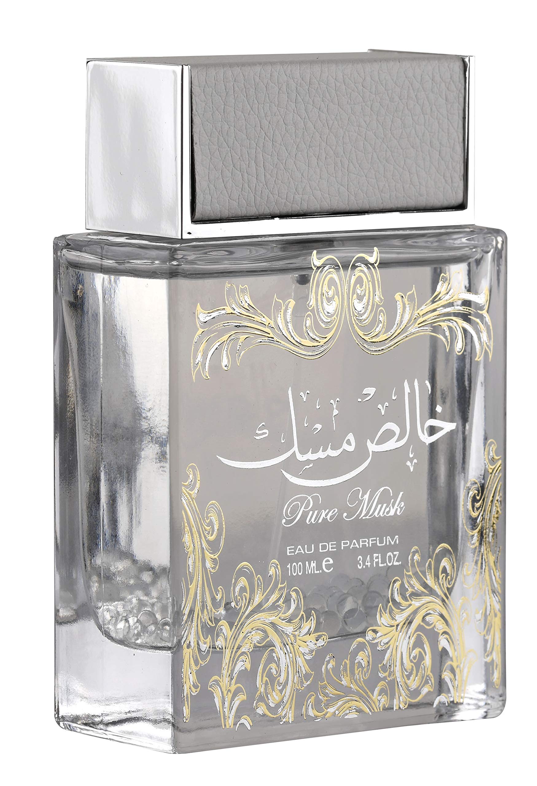 The image is of a square-shaped perfume bottle with the following features:  The bottle is made of clear glass, showcasing the transparent liquid inside. It has a broad, flat silver cap with a textured appearance resembling leather. Decorative golden flourishes adorn the front of the bottle, framing the text. The text on the bottle includes "Pure Musk" in a script font and Arabic calligraphy above it. Below the decorative elements, the bottle states "Eau de Parfum" and the volume "100 mL, 3.4 FL.OZ."