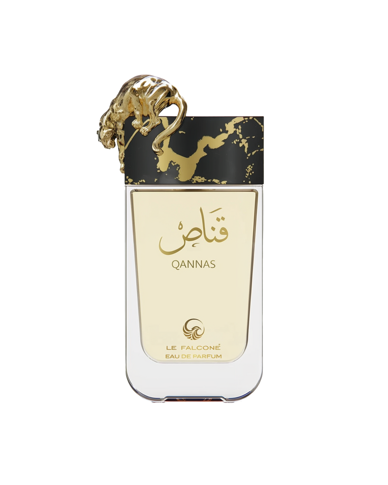 A rectangular, clear glass perfume bottle filled with pale gold liquid, featuring Arabic calligraphy and the word ‘Qannas’ in gold on the front, topped by a sculpted gold big cat, and labeled ‘Le Falcone Eau De Parfum’ at the bottom.
