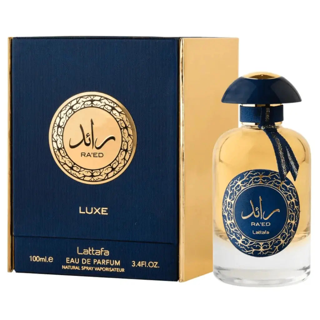 The image features a perfume bottle and its packaging:  The perfume bottle has a clear glass body with a golden-yellow liquid, and a navy blue dome-shaped cap. A navy blue ribbon is tied around the neck of the bottle, complementing the cap. The front of the bottle displays a navy blue label with gold decorative patterns and Arabic calligraphy of the name "RA'ED," with the brand "Lattafa" beneath it. The packaging next to the bottle is a box with a navy blue and gold color scheme. 
