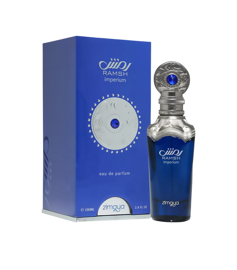 A bottle and packaging of Ramsh Imperium Eau De Parfum by Zimaya. The perfume bottle is a deep blue color with silver metallic detailing at the neck and cap, which features intricate engravings and a prominent blue gemstone-like accent. The label on the bottle reads "RAMSH imperium" along with the Zimaya logo.