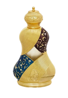 The image shows an ornately designed perfume bottle:  The bottle has a unique, hourglass-like shape with a broad base that tapers to a narrower top and flares out again at the neck. It features a textured gold finish with decorative elements, including a band with a deep blue background and gold arabesque patterns. The cap is textured and dome-shaped, matching the gold theme of the bottle.