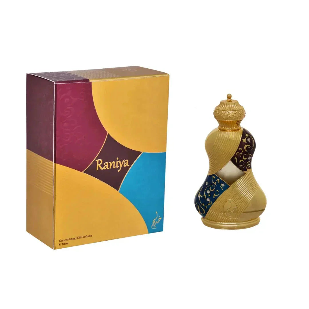 The image depicts a perfume product with its packaging:  The perfume bottle has a traditional, curved shape reminiscent of Middle Eastern design, with a gold finish and intricate blue and gold patterns around its middle. The cap of the bottle is also gold and features a textured design, enhancing the ornate appearance. The packaging box is colorful, with geometric segments in purple, gold, and blue, and has the name "Raniya" printed in a modern sans-serif font.