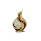 The image shows an intricately designed perfume bottle:  The bottle has a spherical base with a slender, curved neck that extends into a pointed tip, reminiscent of traditional Middle Eastern design. It is predominantly off-white with gold accents and features a decorative red swirl with embedded gem-like stones. Arabic calligraphy is displayed on the lower part of the bottle, adding to its cultural aesthetic. The bottle rests on a small, ornate gold stand.