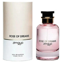 The image shows a bottle of "Rose of Dreams" eau de parfum by Zimaya alongside its packaging. The perfume bottle is cylindrical with a soft pink hue and a clear glass bottom.  The packaging is a cylindrical box with a minimalist design. The upper half of the box is a soft, pearly beige, while the lower half is white with a gold band separating the two sections.