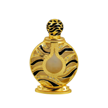 The image displays an ornate perfume bottle:  The bottle has a spherical shape with a flat base, finished in a shiny gold color. It features black and gold patterned designs with inset gem-like crystals. The central part of the bottle has a frosted glass panel. The top of the bottle has a spherical, patterned gold cap.