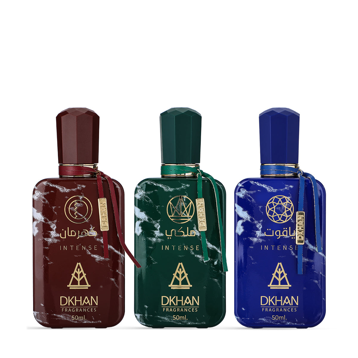 This image features a set of three distinct perfume bottles from DKHAN Fragrances, each containing 50ml of Eau de Parfum. From left to right: the first bottle is maroon with a matching geometric cap and a gold tag, the second bottle is emerald green with a gold tag, and the third is cobalt blue with a gold tag. Each bottle has a marbled effect and is adorned with the DKHAN logo and 'INTENSE' in gold lettering, along with the brand's emblem, a heart within a diamond shape.