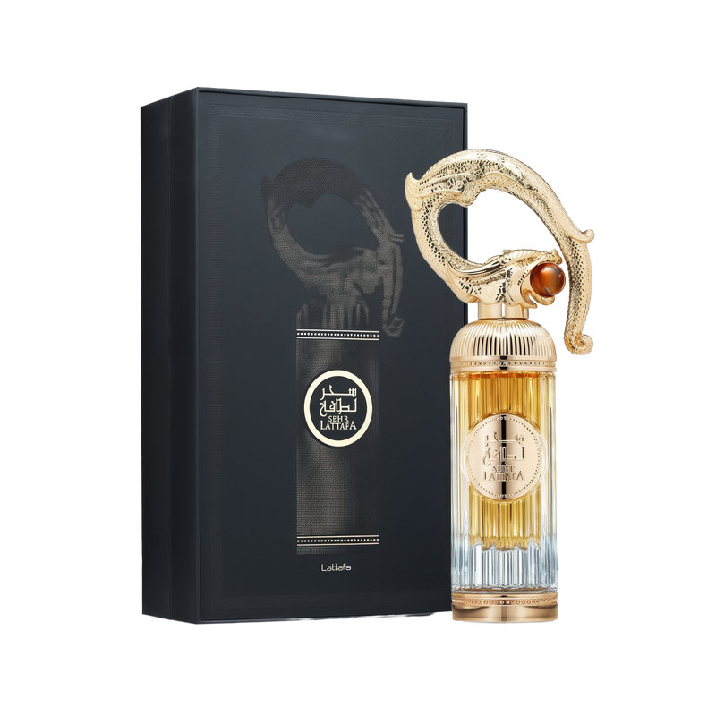 A luxurious bottle of Sehr Lattafa perfume by Lattafa, positioned beside its elegant black box. The tall, ribbed glass bottle transitions from clear at the base to a golden amber hue at the top. The centerpiece is an ornate, sculpted gold cap resembling an Arabian dagger or sword hilt, adorned with intricate detailing and a gemstone-like accent. The circular gold label on the front displays the name 'Sehr Lattafa' in Arabic and English.