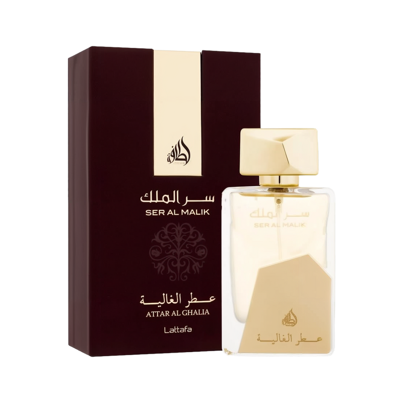 The image shows a clear perfume bottle from Lattafa with gold accents and the name "Ser Al Malik" in both Arabic and English. The bottle features a unique design with a large geometric gold cap and a matching gold label at the bottom. The text "Attar Al G