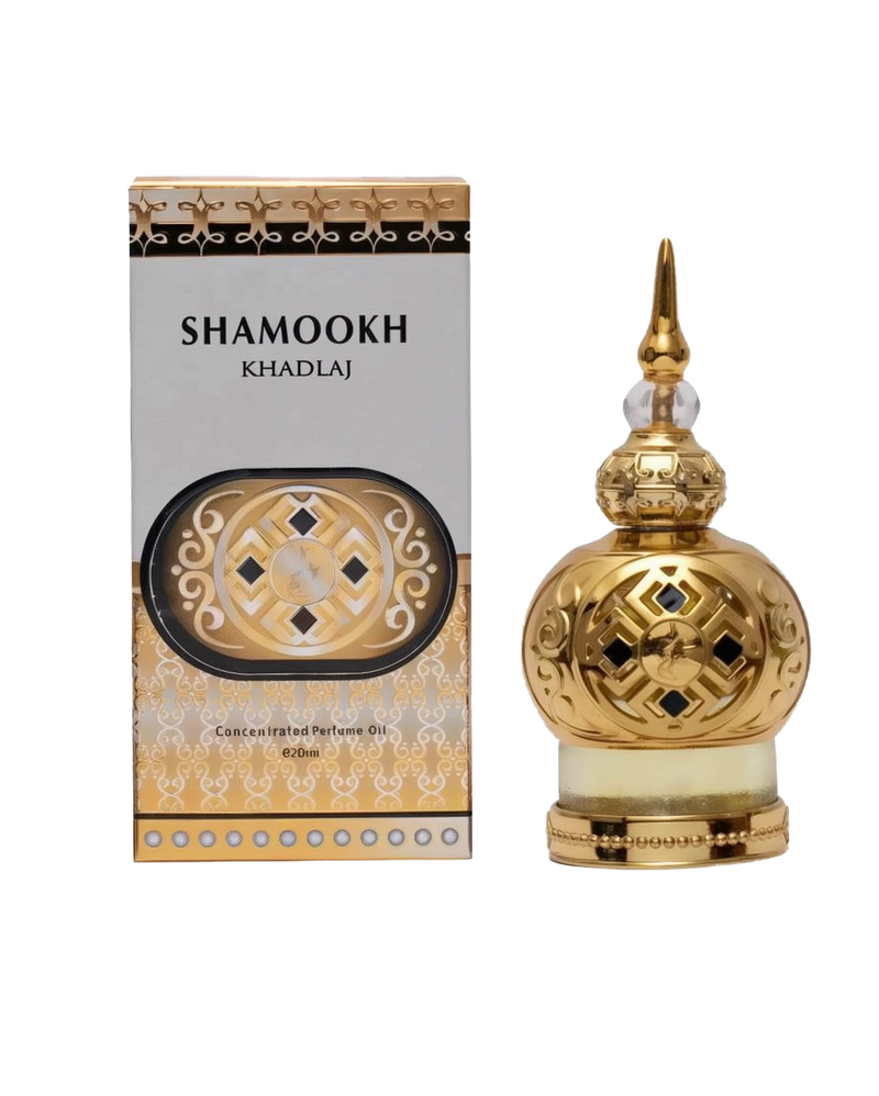 The image shows a product called "Shamookh" by Khadlaj, which is a concentrated perfume oil. The product is presented in an ornate 20ml bottle with a spherical design. The bottle is gold with intricate patterns and a decorative, pointed cap, giving it a luxurious and elegant appearance. The packaging box complements the bottle's design with a gold and black theme, featuring the product name "Shamookh" in bold letters.